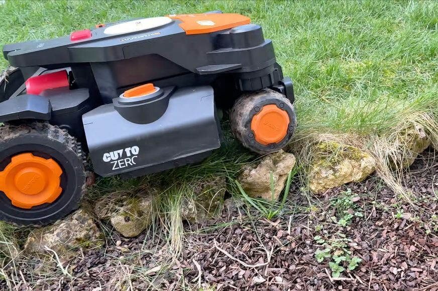 Mähroboter fährt auf einen Randstein im Steigung und unebenes Gelände Mähroboter Test